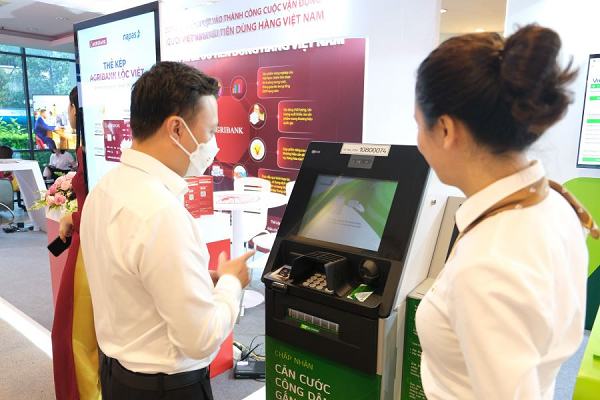 Cán bộ Vietcombank tư vấn khách hàng sử dụng dịch vụ ngân hàng số (ảnh trên) và dịch vụ ATM tại gian hàng trưng bày
