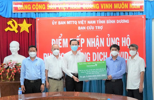 Ông Nguyễn Văn Lộc - Chủ tịch Ủy ban Mặt trận tổ quốc tỉnh Bình Dương (thứ 2 từ phải sang) đại diện lãnh đạo tỉnh Bình Dương tiếp nhận kinh phí ủng hộ phòng chống dịch COVID-19 của Vietcombank