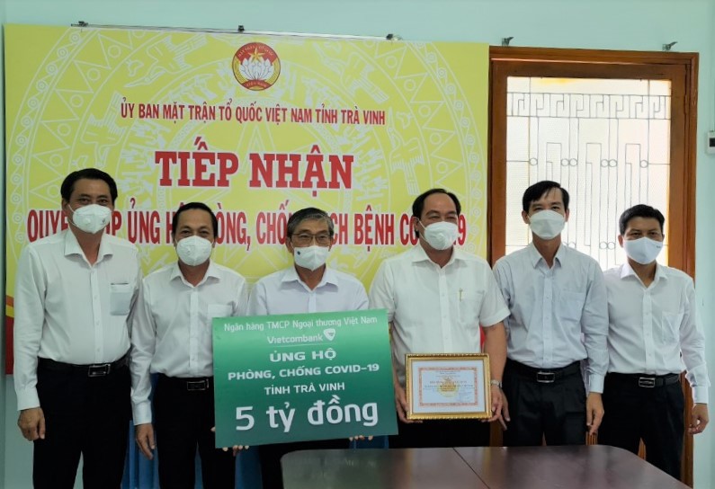 Đại diện Vietcombank, Đỗ Tất Khá - Giám đốc Vietcombank Trà Vinh (thứ 3 từ phải sang) trao biển tượng trưng số tiền 5 tỷ đồng hỗ trợ công tác phòng, chống dịch COVID-19 của tỉnh Trà Vinh cho ông Nguyễn Văn Triết - Chủ tịch Ủy ban MTTQ Việt Nam tỉnh Trà Vinh