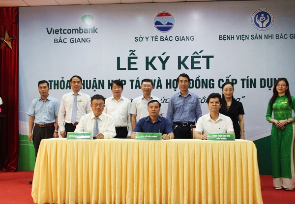 Ông Lê Hồng Tâm – Giám đốc Vietcombank Bắc Giang (hàng ngồi, ngoài cùng bên trái) ký kết thỏa thuận hợp tác với đại diện Sở Y tế và Bệnh viện Sản – Nhi Bắc Giang