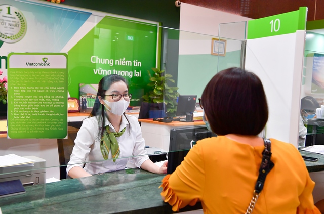Khách hàng và nhân viên Vietcombank tuân thủ các quy định về phòng, chống dịch COVID-19 khi thực hiện giao dịch tại ngân hàng