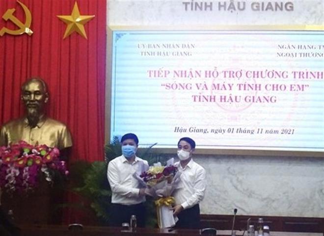 Ông Nghiêm Xuân Thành, Ủy viên BCH Trung ương Đảng, Bí thư Tỉnh ủy Hậu Giang (bên phải) tặng hoa cảm ơn sự quan tâm, hỗ trợ của Vietcombank