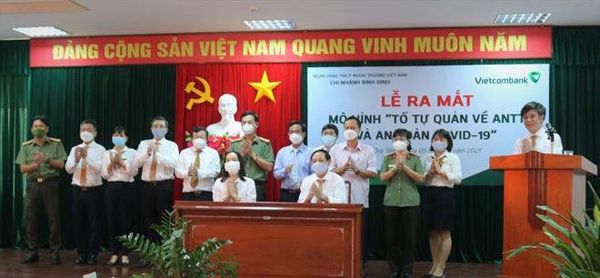 Ông Nguyễn Văn Thúy – Giám đốc Vietcombank Bình Định (thứ 5 từ phải sang) cùng ông Ngô Cự Vinh – Phó Giám đốc Công an tỉnh Bình Định (thứ 6 từ trái sang) chứng kiến lễ ký kết thực hiện quy chế hoạt động mô hình “Tổ tự quản về an ninh trật tự và an toàn Covid-19”