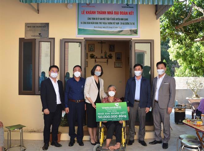 Bà Phạm Minh Đào - Phó Giám đốc chi nhánh (thứ ba từ trái sang), đại diện Công đoàn cơ sở Vietcombank Hải Dương trao biển tặng nhà đại đoàn kết cho bà Nguyễn Thị Gái