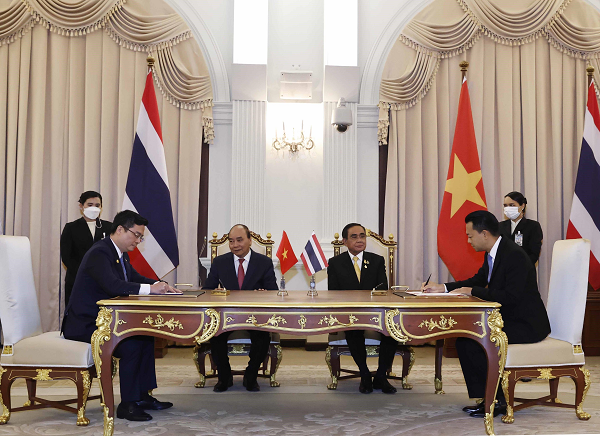 Ông Nguyễn Thanh Tùng, Phó Tổng Giám đốc phụ trách Ban Điều hành Vietcombank (bên trái) và ông Rak Vorrakitpokatorn - Tổng Giám đốc Eximbank Thái Lan ký kết thỏa thuận hợp tác trước sự chứng kiến của Chủ tịch nước Nguyễn Xuân Phúc và Thủ tướng Thái Lan Prayuth Chan-ocha.