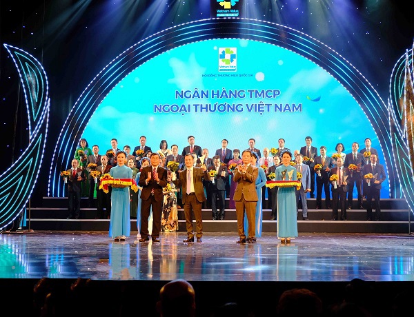 Đại diện Vietcombank, ông Lê Hoàng Tùng – Kế toán trưởng nhận biểu trưng Thương hiệu quốc gia cùng hoa chúc mừng từ Bộ trưởng Bộ Công thương Trần Tuấn Anh và đại diện Hội đồng Thương hiệu Quốc gia
