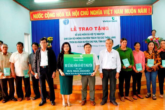 Bà Đỗ Thị Việt Hằng - Giám đốc Vietcombank Gia Lai trao tặng 100 sổ Bảo hiểm xã hội cho các cán bộ không chuyên trách thôn làng trước sự chứng kiến của đại diện lãnh đạo địa phương