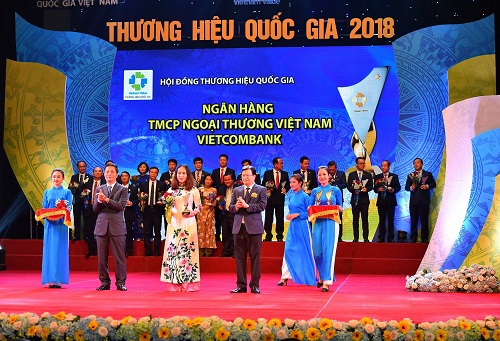 Phó Tổng giám đốc Vietcombank Nguyễn Thị Kim Oanh nhận Biểu trưng và hoa chúc mừng từ Phó Thủ tướng Chính phủ Trịnh Đình Dũng và Bộ trưởng Bộ Công Thương Trần Tuấn Anh