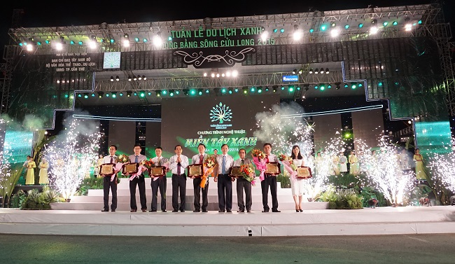 Ông Đào Minh Tú – Phó Thống đốc Ngân hàng Nhà nước Việt Nam (thứ 4 từ phải sang) trao Bảng vàng ghi nhận đóng góp chương trình “Tuần lễ du lịch xanh ĐBSCL năm 2015” cho ông Đào Hảo – Phó Tổng giám đốc Vietcombank (thứ 3 từ phải sang).