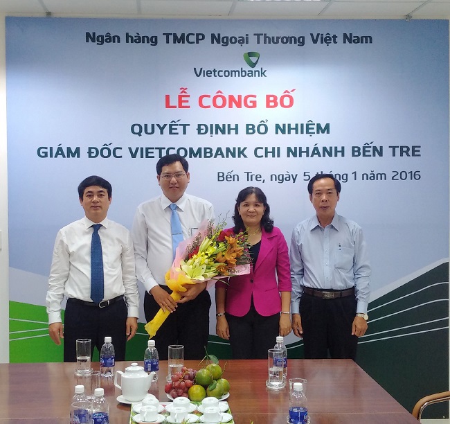 Ông Nghiêm Xuân Thành - Chủ tịch HĐQT Vietcombank (ngoài cùng bên trái) trao quyết định và tặng hoa cho tân Giám đốc Vietcombank Bến Tre
