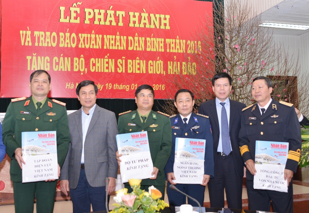 Ông Phạm Mạnh Thắng - Phó Tổng giám đốc Vietcombank (thứ 2 từ phải sang) vàông Lê Quốc Khánh - Phó Tổng biên tập Báo Nhân Dân (thứ 2 từ trái sang) gửi tặng ấn phẩm Báo Nhân Dân Xuân Bính Thân đến cán bộ, chiến sỹ biên giới hải đảo