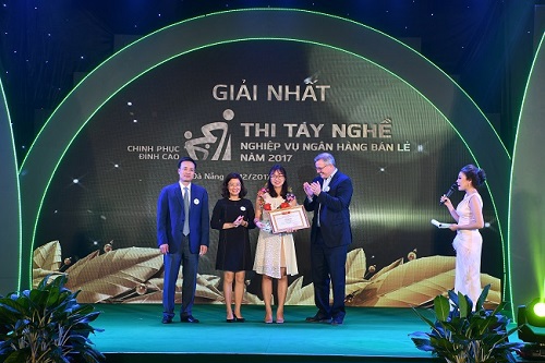 Ông Phạm Quang Dũng – Tổng Giám đốc Vietcombank (ngoài cùng bên trái) và ông Thomas William Tobin – Giám đốc Khối bán lẻ (thứ 4 từ trái sang) trao giải Nhất cho thí sinh Viên Ngọc Bích và chúc mừng đại diện Ban giám đốc Trung tâm Thẻ