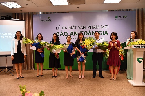Bà Đoàn Hồng Nhung – Trưởng phòng Quản lý Bán sản phẩm bán lẻ, Thành viên Hội đồng thành viên Công ty VCLI (Thứ 2 từ phải sang) và bà Young Lai Yin – Tổng Giám đốc VCLI (ngoài cùng bên trái) tặng hoa chúc mừng các khách hàng tham gia sản phẩm Bảo An Toàn