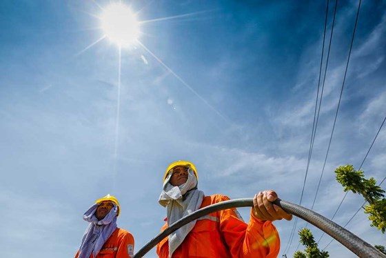 Công nhân điện lực phải làm việc dưới trời nắng như thiêu đốt. Ảnh: EVN