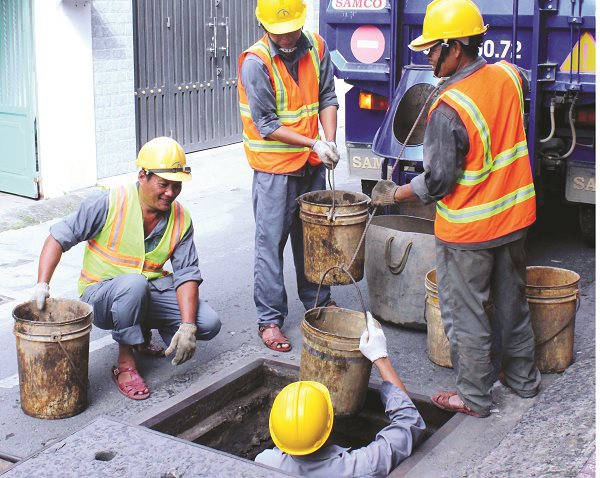 Công nhân nạo vét cống xử lý nước thải ở TPHCM.
