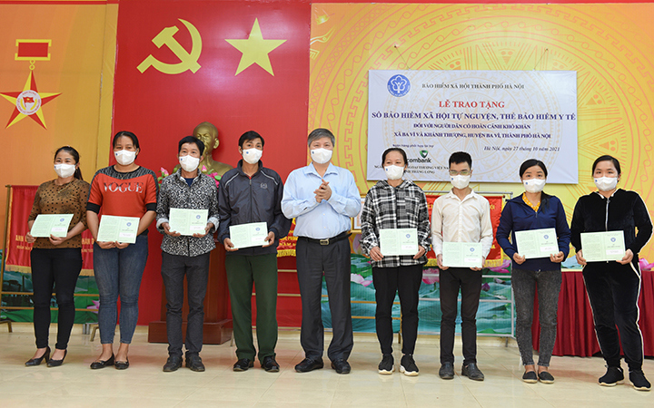 Trao sổ bảo hiểm xã hội tự nguyện cho người dân tại huyện Ba Vì (Ảnh: Bảo hiểm xã hội Hà Nội).