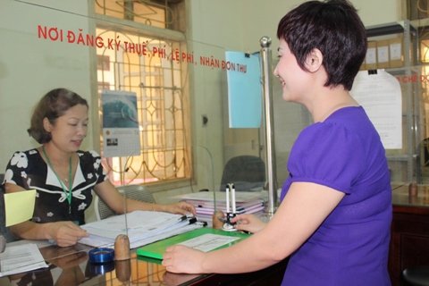 Hộ gia đình tìm hiểu về chính sách thuế khoán tại bộ phận "một cửa" Chi Cục Thuế TP.Yên Bái. Ảnh: NM.
