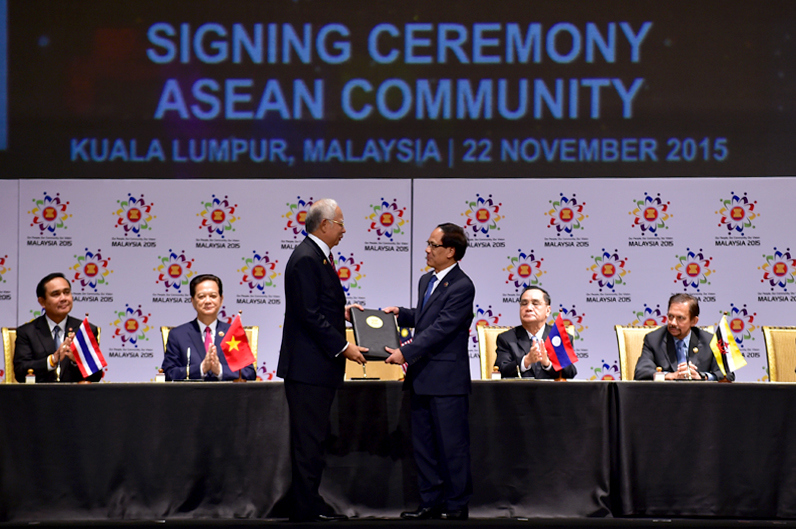 Thủ tướng Malaysia Najib Tun Abdul Razak trao các văn kiện liên quan về việc thành lập Cộng đồng ASEAN cho Tổng Thư ký ASEAN Lê Lương Minh. Ảnh: VGP/Nhật Bắc