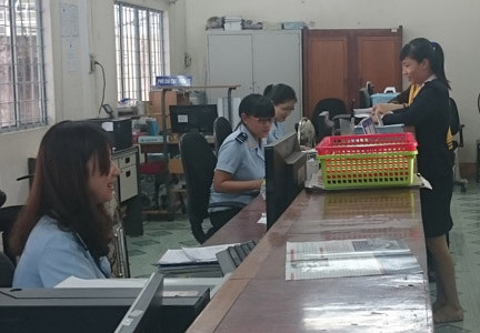Cán bộ Hải quan An Giang hướng dẫn DN mở tờ khai XNK. Ảnh: Kim Phượng