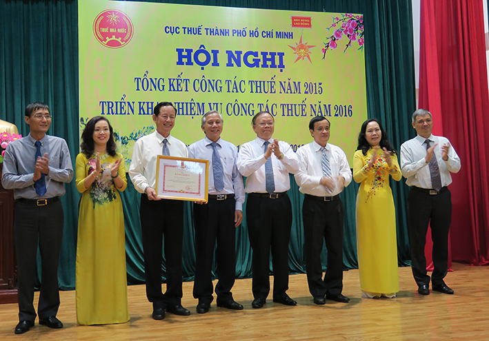 Tổng cục trưởng Tổng cục Thuế Bùi Văn Nam tặng bằng khen cho các cán bộ có thành tích năm 2015.