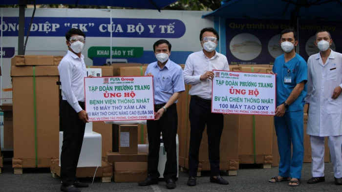 Ông Đào Viết Ánh (bìa trái) trao tặng số máy thở cho PGS-TS-BS Lê Đình Thanh, Giám đốc BV Thống Nhất và đại diện BV dã chiến điều trị bệnh nhân Covid-19 đa tầng Tân Bình.