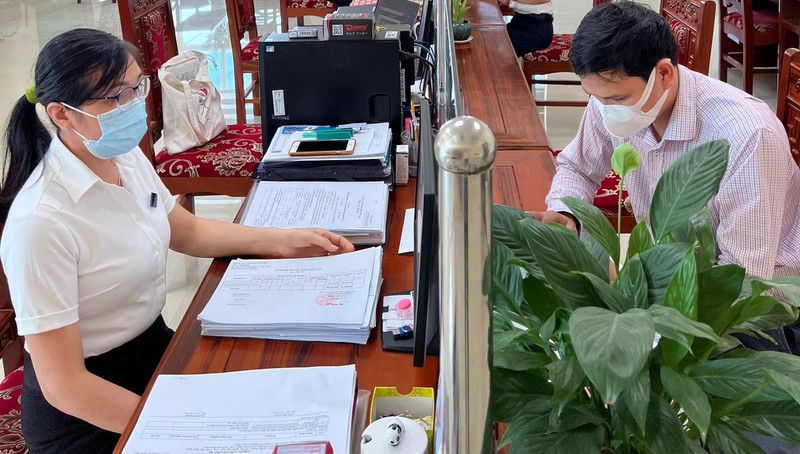 Công chức bộ phận tuyên truyền ngành Thuế tỉnh Bình Định hỗ trợ người nộp thuế. baophapluat.vn