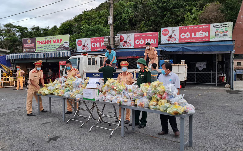 Cảnh sát giao thông Thừa Thiên Huế cùng các ban, ngành huyện Phú Lộc tiếp tế lương thực, nước uống cho người dân từ TP Hồ Chí Minh tại chốt kiểm soát y tế.