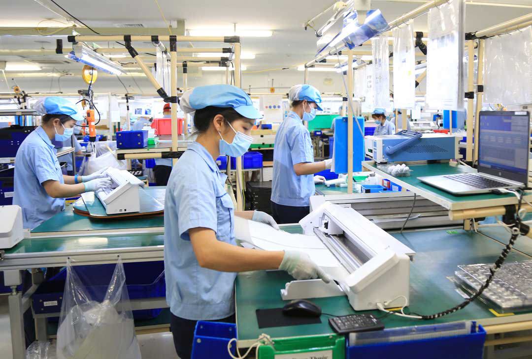 Công nhân vừa tuân thủ các biện pháp phòng, chống dịch COVID-19, vừa đẩy mạnh sản xuất thiết bị điện tử tại Công ty TNHH Rhythm Precision Việt Nam, KCN Nội Bài, huyện Sóc Sơn, TP. Hà Nội. Ảnh: hanoimoi.com.vn