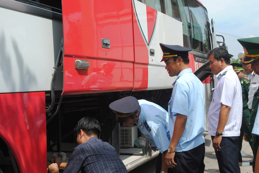 Lực lượng chức năng tại cửa khẩu Mộc Bài kiểm tra xe buýt nhập cảnh. Nguồn: baohaiquan.vn