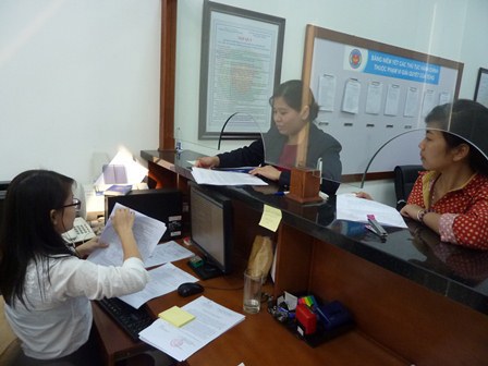 Cán bộ hải quan bộ phận cơ chế một cửa hành chính tiếp nhận hồ sơ của doanh nghiệp. Nguồn: PV.