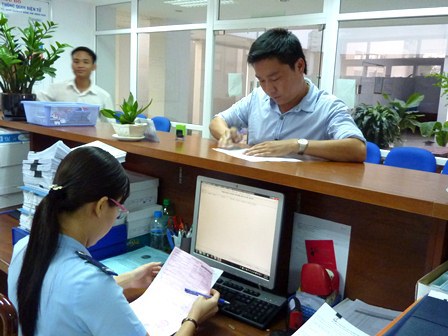 Cán bộ Hải quan Bình Dương hỗ trợ DN hoàn thiện tờ khai. Nguồn: PV.