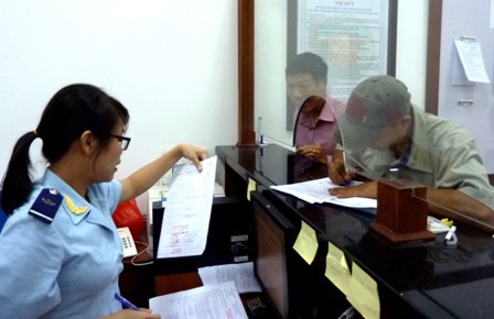 Cán bộ hải quan bộ phận một cửa hành chính trả kết quả hồi đáp thủ tục thuế XNK cho DN.