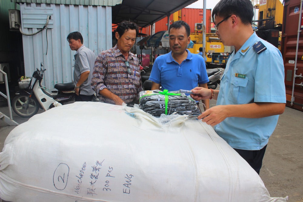 Cán bộ Đội 4 khám xét lô hàng giả nhập khẩu từ Trung Quốc. Nguồn: PV.