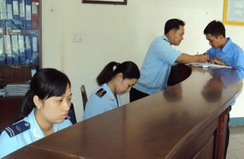 Cán bộ Hải quan Đắk Lắk hướng dẫn doanh nghiệp hoàn thiện tờ khai hàng hóa. Nguồn: PV.