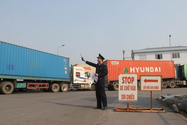 Công chức Hải quan Hải Phòng điều tiết, hướng dẫn tài xế điều khiển phương tiện vào khu vực soi container. Nguồn: PV.