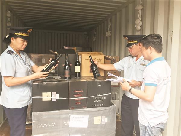 Doanh nghiệp chấp hành tốt pháp luật sẽ được tạo thuận lợi tốt nhất. Trong ảnh: Công chức Hải quan TP.HCM kiểm tra rượu nhập khẩu. Nguồn: PV.