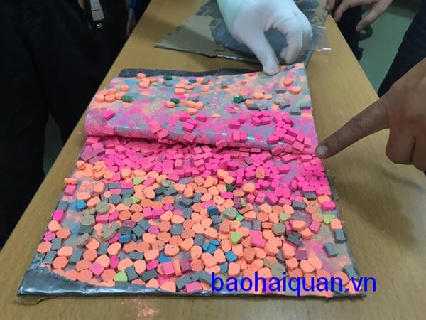 Hàng ngàn viên ma túy được dính băng keo ép trong thành thùng carton bị Hải quan TP.HCM bắt giữ. Nguồn: PV.