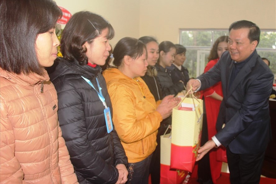 Bộ trưởng Bộ Tài chính Đinh Tiến Dũng trao quà cho người lao động có hoàn cảnh khó khăn đang làm việc tại Công ty TNHH May Vạn Lợi. Ảnh: NT