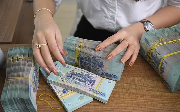  Kiểm đếm tiền mặt tại một ngân hàng cổ phần. Ảnh: Giang Huy. 