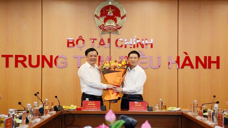 Bộ trưởng Bộ Tài chính Hồ Đức Phớc tặng hoa Bí thư Thành ủy Hà Nội Đinh Tiến Dũng.