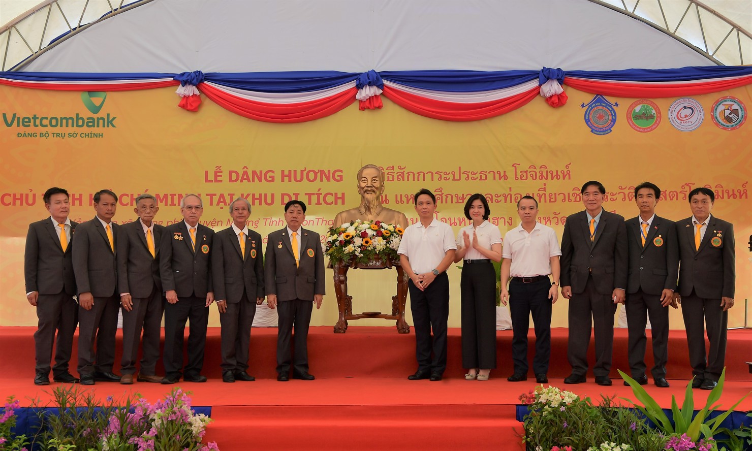 Đ/c Đỗ Việt Hùng – Phó Bí thư thường trực Đảng ủy Vietcombank (thứ 4 từ phải sang) cùng đ/c Nguyễn Mạnh Hùng – Bí thư Đảng ủy TSC (thứ 6 từ phải sang) và đ/c Phùng Nguyễn Hải Yến – Phó Bí thư Đảng ủy TSC (thứ 5 từ phải sang) trao tặng tượng Chủ tịch Hồ Chí Minh cho BQL Khu di tích Chủ tịch Hồ Chí Minh – tỉnh Udon Thani, Thái Lan