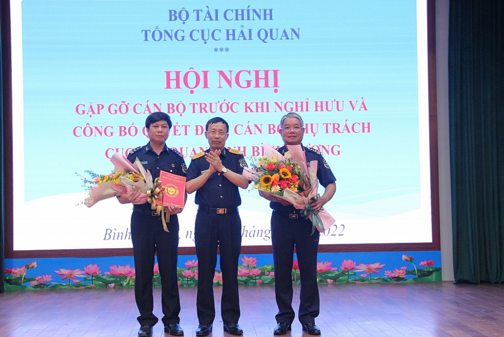 Tổng cục trưởng Tổng cục Hải quan Nguyễn Văn Cẩn trao quyết định nghỉ hưu cho đồng chí Nguyễn Phước Việt Dũng và trao quyết định phụ trách Cục Hải quan Bình Dương cho đồng chí Nguyễn Trường Giang - Phó Cục trưởng Cục Hải quan Bình Dương . Ảnh: Phi Vũ.