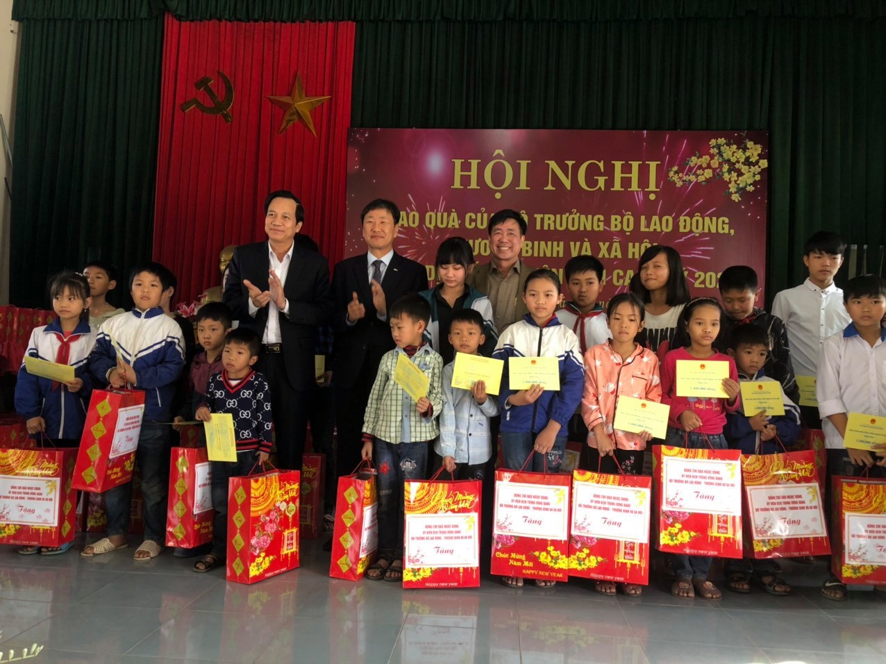 Bộ trưởng Bộ Lao động Thương binh và Xã hội Đào Ngọc Dung và Giám đốc Quỹ Bảo trợ trẻ em Việt Nam Hoàng Văn Tiến trao học bổng và quà cho trẻ em có hoàn cảnh khó khăn (Ảnh chụp trước thời điểm bùng phát dịch Covid-19).