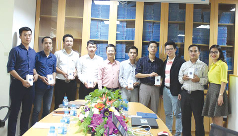 Ông Nghiêm Xuân Thái, Phó Tổng giám đốc PTI (thứ 5 từ trái sang) trao điện thoại Iphone cho các giám định viên.