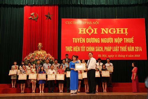 Tổng cục trưởng Tổng cục Thuế Bùi Văn Nam trao tặng giấy khen cho người nộp thuế thực hiện tốt chính sách, pháp luật thuế năm 2014. Ảnh: Văn Trường