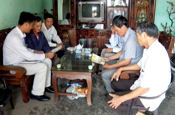 Cán bộ Bảo hiểm Xã hội đến từng thôn và hộ dân tuyên truyền, vận động mua bảo hiểm y tế. Nguồn: internet.