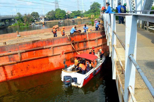 Cầu đường sắt Bình Lợi cũ có tĩnh không thấp nên thường xuyên "bẫy" sà lan. Do đó, việc làm cầu mới và nạo vét luồng lạch sông Sài Gòn theo hình thức BOT là cần thiết trong điều kiện ngân sách eo hẹp. (Ảnh: Gia Minh)