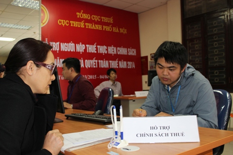 Cán bộ Cục Thuế TP.Hà Nội hướng dẫn cá nhân thực hiện quyết toán thuế TNCN. Ảnh: NM.