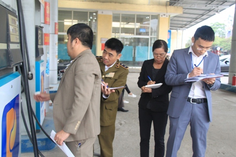Đại diện Cục thuế Thái Nguyên và đoàn liên ngành tiến hành chốt số đồng hồ cột bơm xăng, dầu trước khi tiến hành dán tem niêm phong. Ảnh: Văn Tuấn
