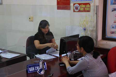 Cán bộ kho bạc kiểm tra hồ sơ, thủ tục của khách hàng đến giao dịch.